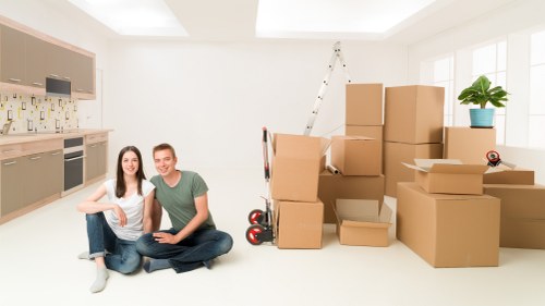 Movers carrying furniture through a stairwell in a Homerton flat