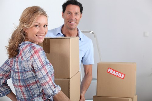 Removal team carrying household boxes in a Homerton flat move